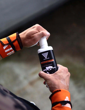 Athlet öffnet GORNATION Premium Liquid Chalk und trägt die GORNATION Wrist Wraps Orange